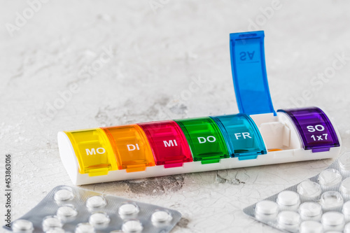 Obraz na plátne Colorful pill box for weekly dosing on a white background, abbreviations for day