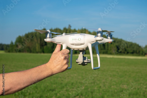A man hand holds a quadrocopter close-up