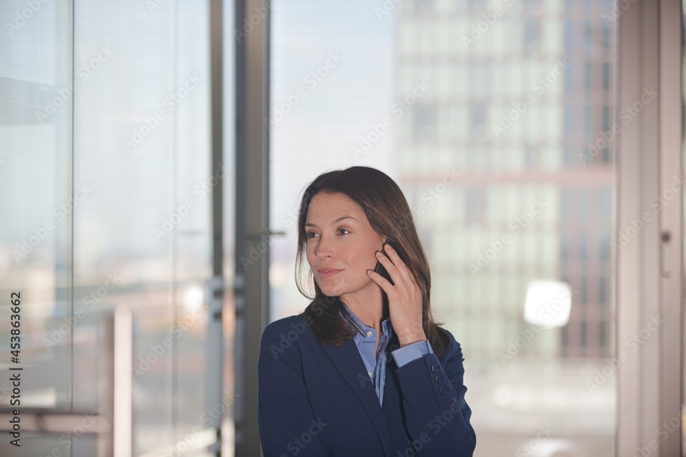 Businesswoman using cell phone in office Businesswoman using cell phone in office