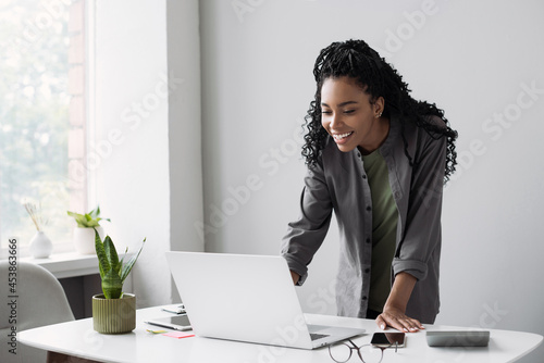 Young woman using laptop computer at office. Student girl working at home. Work or study from home, freelance, business, lifestyle concept