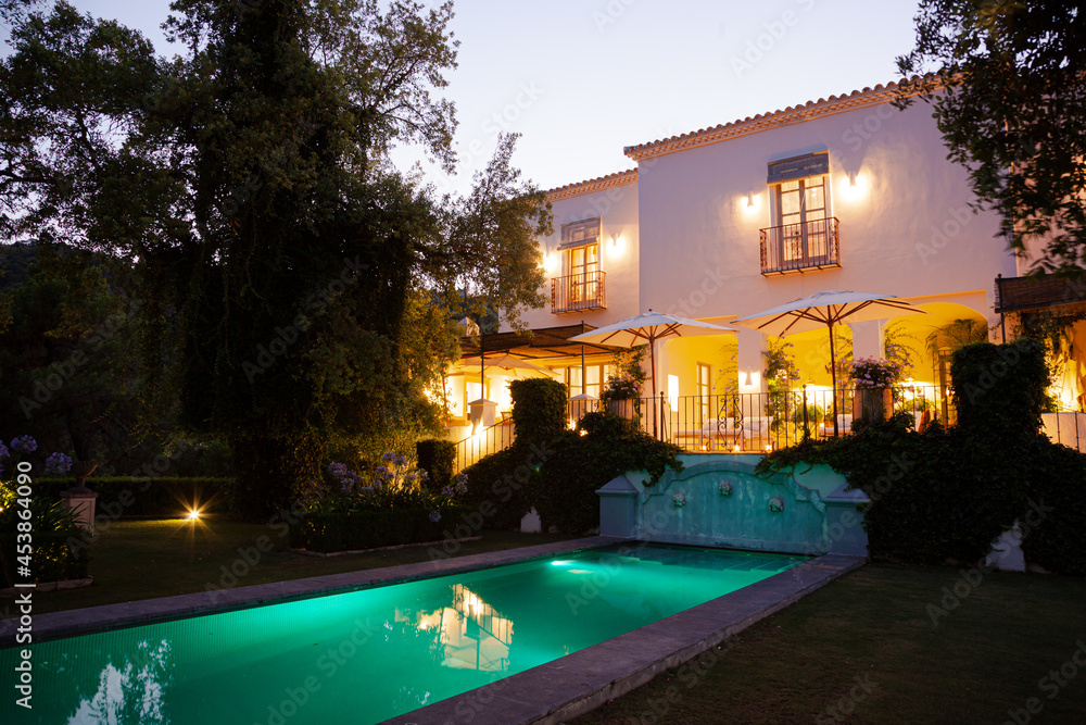 Luxury swimming pool and villa illuminated at night