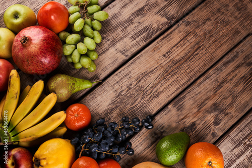 Mix of fresh juicy colorful exotic tropical fruits on wooden background top view with copy space