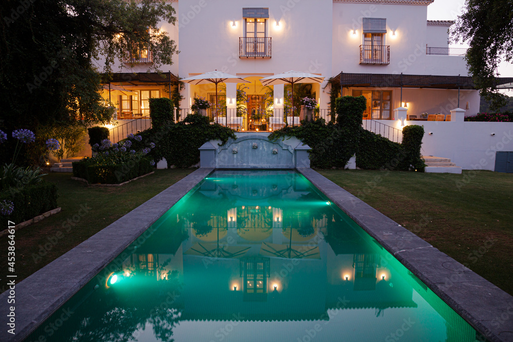 Luxury swimming pool and villa illuminated at night