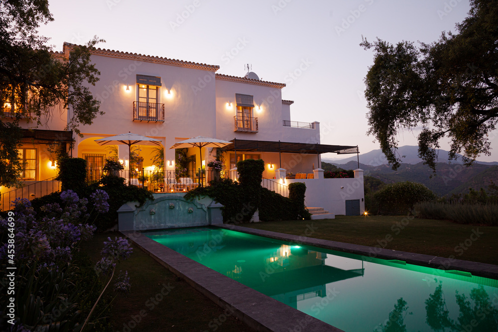 Luxury swimming pool and villa illuminated at night Luxury swimming pool and villa illuminated at night