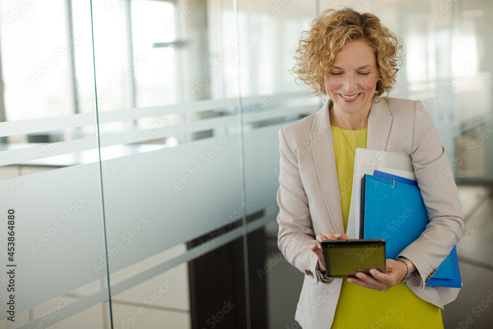 Businesswoman using digital tablet in office hallway Businesswoman using digital tablet in office hallway