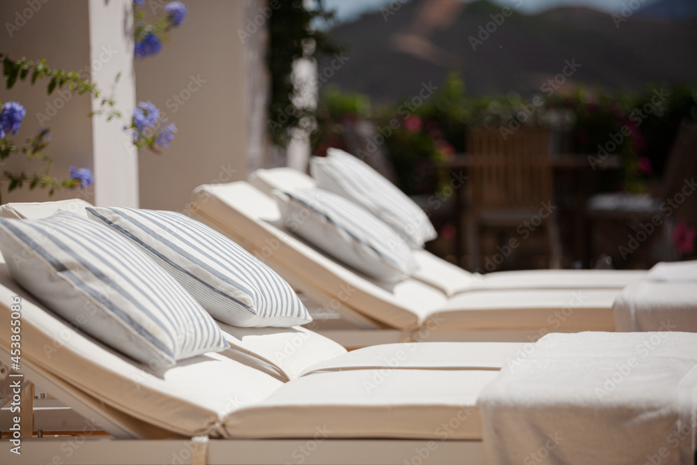 Lounge chairs and towels at poolside of luxury hotel Lounge chairs and towels at poolside of luxury hotel