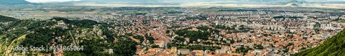 Fototapeta Naklejka Na Ścianę i Meble -  Aerial panoramic view of Brasov surrounded by the Carpathian mountains dotted with ski resorts including the ever popular Boiana Brasov. Romania, the Balkans, Eastern Europe