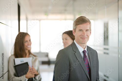 Businessman smiling in office hallway