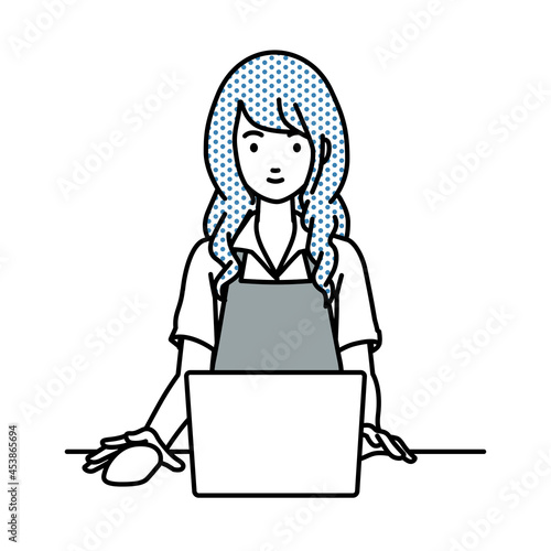 デスクで座ってPCを使っているカフェ店員の女性
