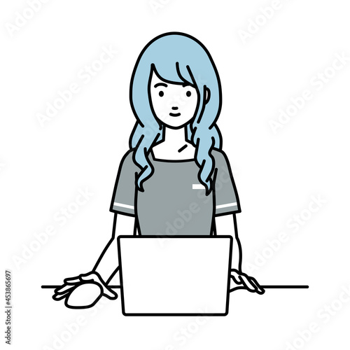 デスクで座ってPCを使っているエステ店員の女性