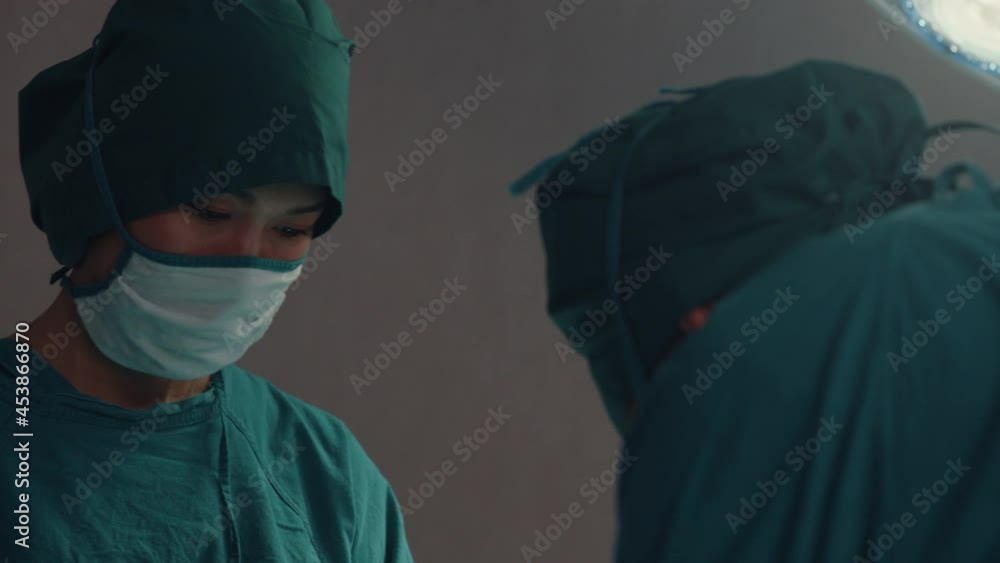 Young Asian assistants and nurses performing invasive surgery on patient in hospital operating room. Diverse team of professional surgeon, Healthcare and medical concept. Young Asian assistants and nurses performing invasive surgery on patient in hospital operating room. Diverse team of professional surgeon, Healthcare and medical concept.