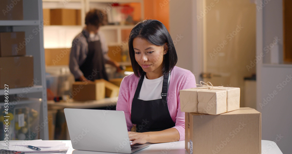 Young afro businesswoman check product purchase order on stock and save to laptop work at office Young afro businesswoman check product purchase order on stock and save to laptop work at office