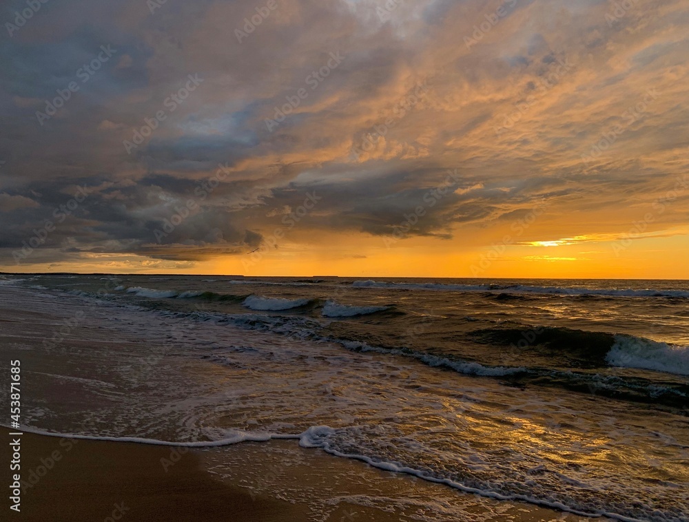 Peaceful sunset at the sea, sand beach, yellow orange sunset