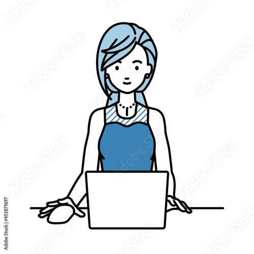 デスクで座ってPCを使っているドレスの女性