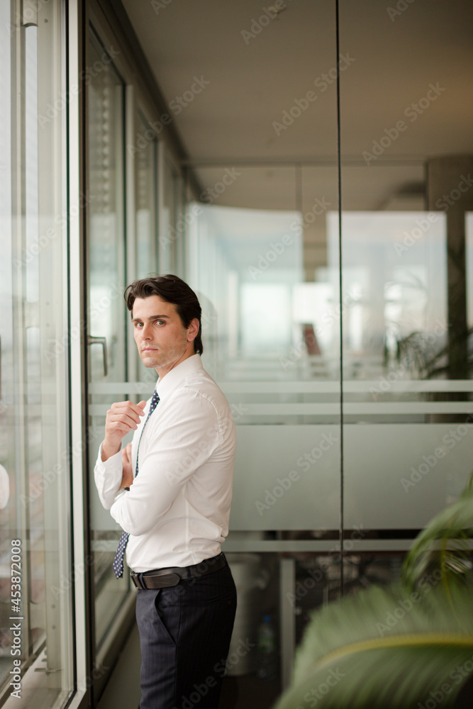 Businessman standing at office window Businessman standing at office window