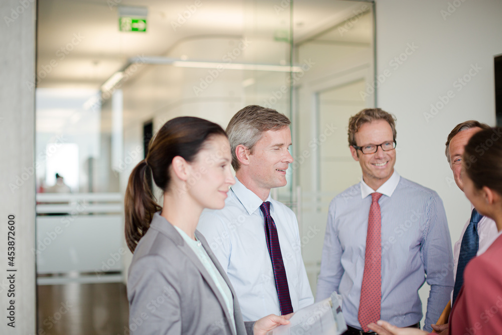 Business people talking in office hallway Business people talking in office hallway