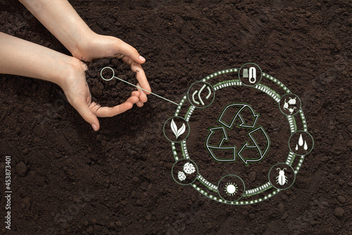 hands with soil on the background of the earth, bio icon, the concept of biodegradable materials, waste-free, eco-friendly recycling, natural fertilizers, organic products and eco friendly farming photo