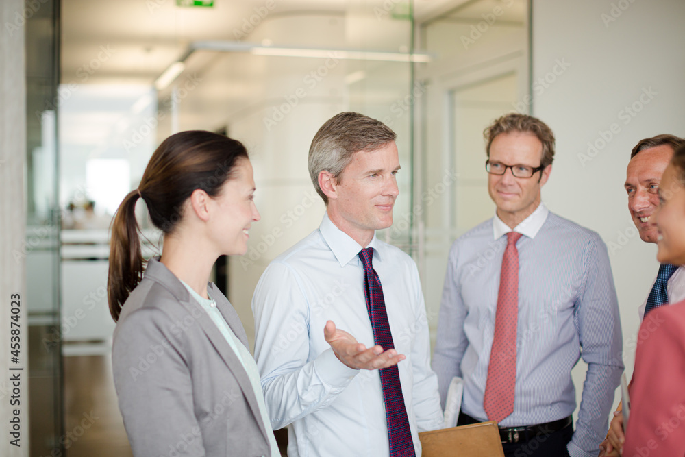 Business people talking in office hallway Business people talking in office hallway