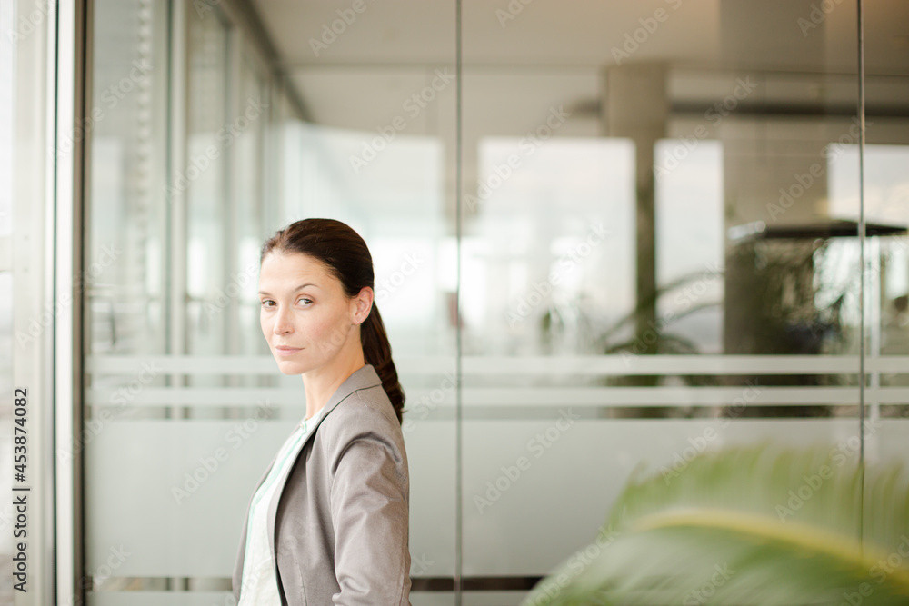 Businesswoman standing at office window Businesswoman standing at office window