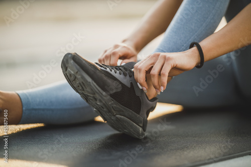 Woman Tying Her Shoelaces While Exercising Outdoors