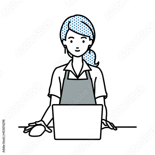 デスクで座ってPCを使っているカフェ店員の女性