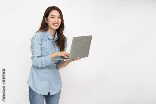 Happy young Asian woman holding laptop computer isolated over white background and Looking at camera