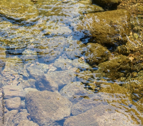 A close view of the rocks and stones in the clear water.