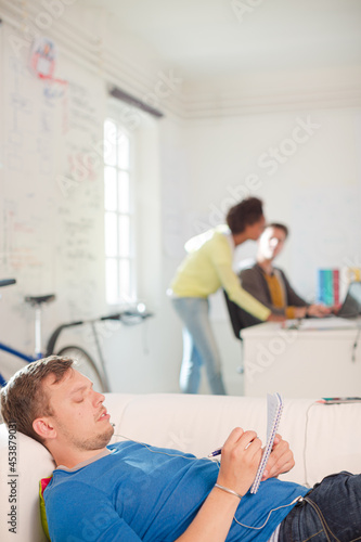 Businessman taking notes on sofa in office