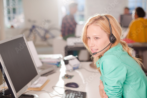 Businesswoman talking on headset at desk