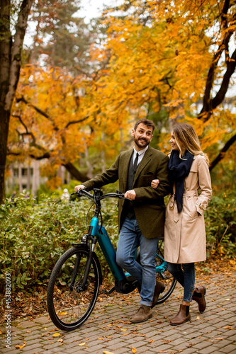 Young couple in the autumn park with electrical bicycle © BGStock72