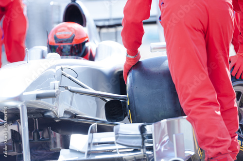 Racing team changing car wheel on pit stop