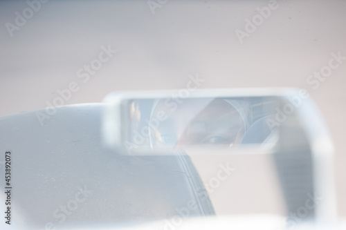Close up of car side-view mirror with reflection of racer
