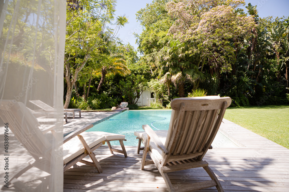 Lawn chairs and swimming pool in backyard Lawn chairs and swimming pool in backyard