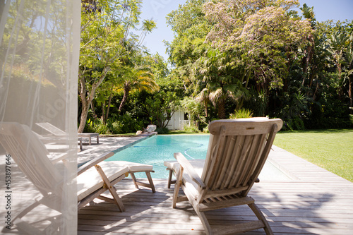 Lawn chairs and swimming pool in backyard © KOTO