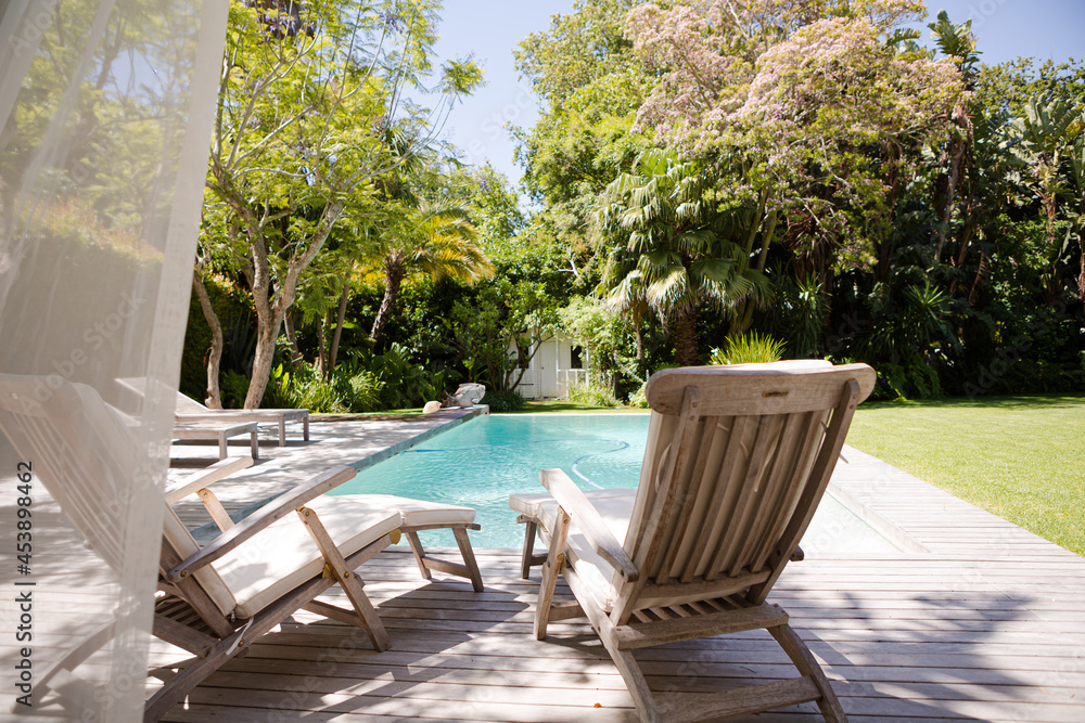 Lawn chairs and swimming pool in backyard Lawn chairs and swimming pool in backyard