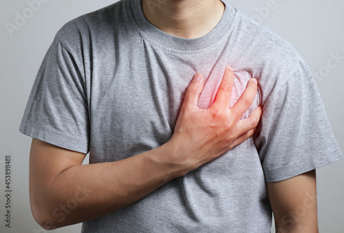 Heart attack problems. Young male suffering from severe chest pain. Warning signs of terrible disease. Health care and cardiological concept.