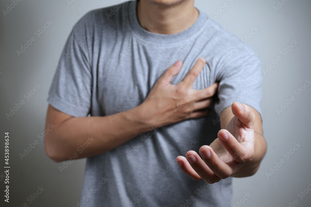 Heart attack problems. Young male suffering from severe chest pain and he is reaching out for help. Warning signs of terrible disease. Health care and cardiological concept. Heart attack problems. Young male suffering from severe chest pain and he is reaching out for help. Warning signs of terrible disease. Health care and cardiological concept.
