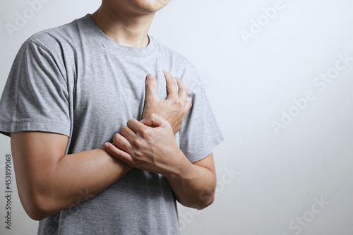 Heart attack problems. Young male suffering from severe chest pain. Warning signs of terrible disease. Health care and cardiological concept.