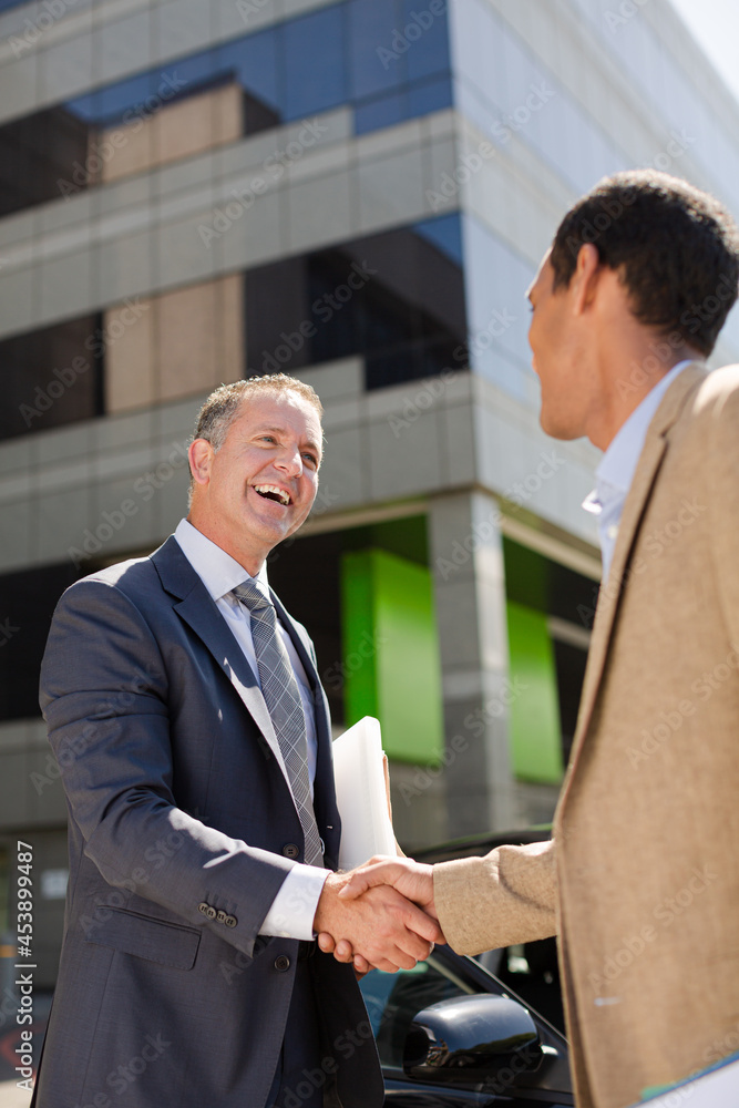 Businessmen shaking hands outdoors Businessmen shaking hands outdoors