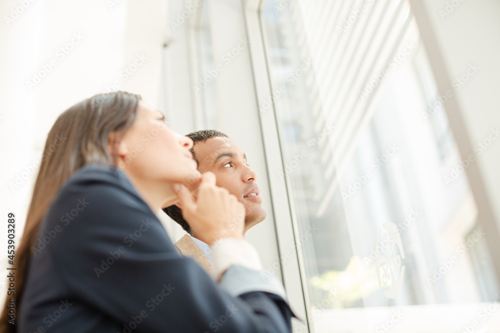 Business people talking in office next to window Business people talking in office next to window