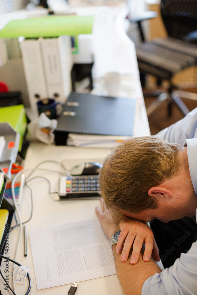 Businessman resting head on desk Businessman resting head on desk