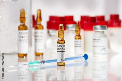 Viales vacuna Covid-19 con medicamentos varios y botella de alcohol en gel