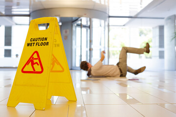 Businessman slipping on wet office floor