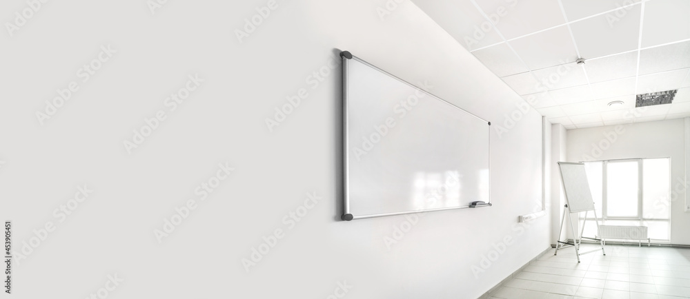 Empty training seminar room with large white chalkboard Empty training seminar room with large white chalkboard