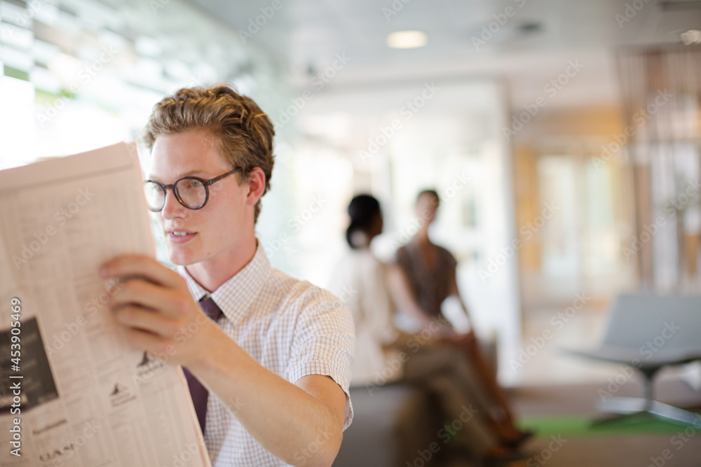 Fototapeta premium Businessman reading newspaper in office