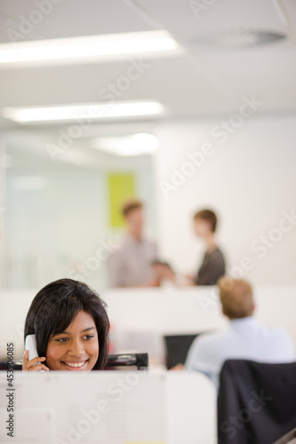 Businesswoman talking on phone at desk