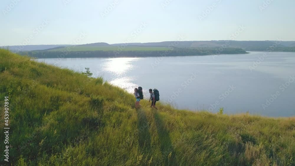 The young couple hike on the beautiful river background The young couple hike on the beautiful river background