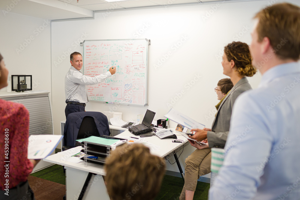 Businessman drawing on whiteboard in meeting Businessman drawing on whiteboard in meeting