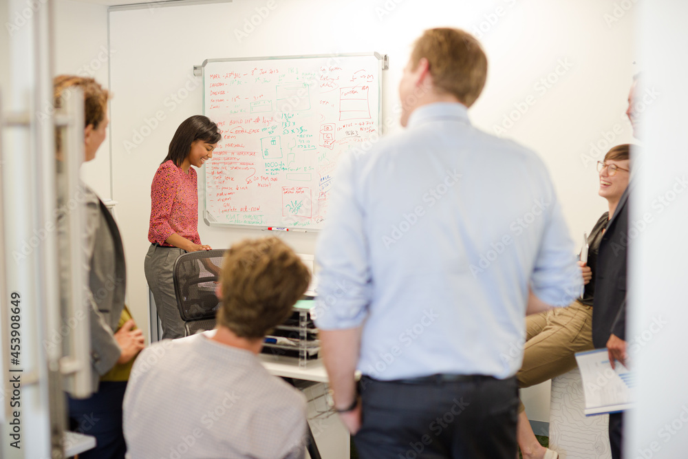 Obraz premium Businesswoman drawing on whiteboard in meeting