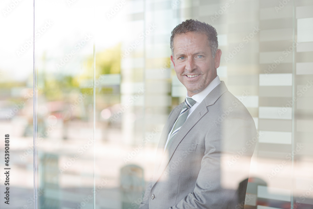 Businessman smiling at office window